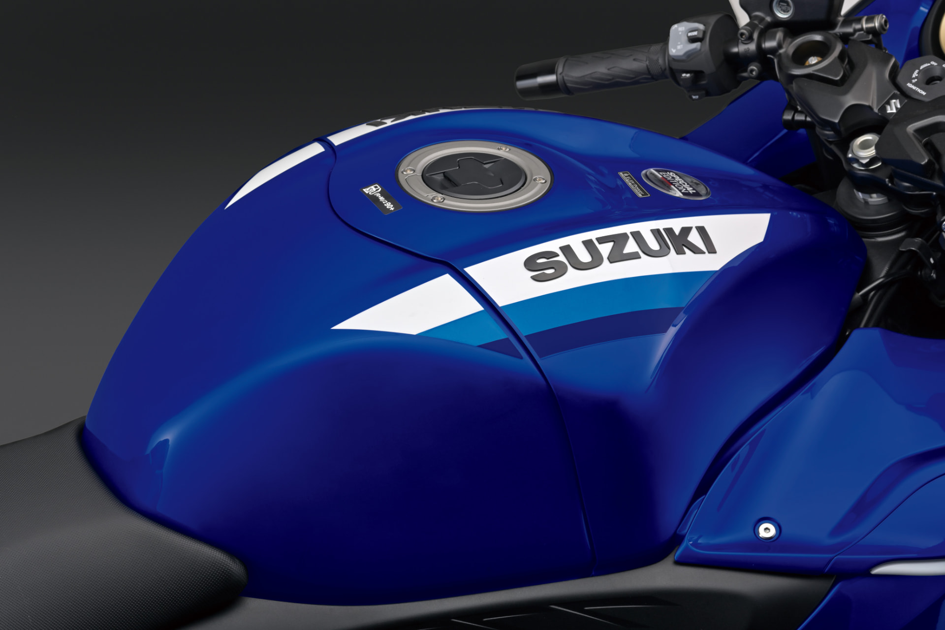 Detalhe do tanque azul com grafismos brancos e logotipo Suzuki